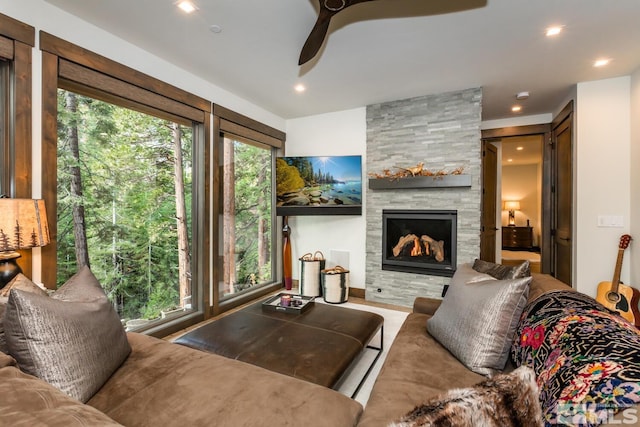 living room featuring ceiling fan and a fireplace