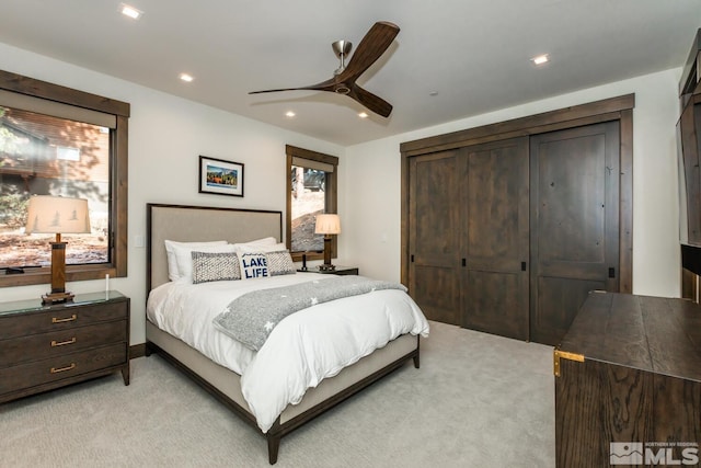 carpeted bedroom with ceiling fan and a closet