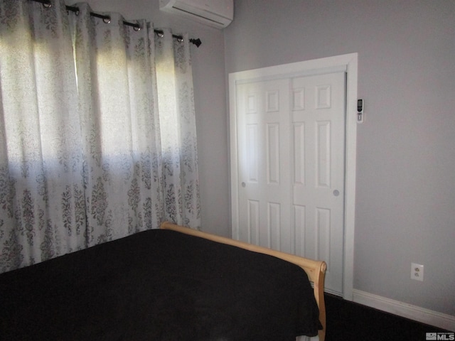 unfurnished bedroom with an AC wall unit and baseboards