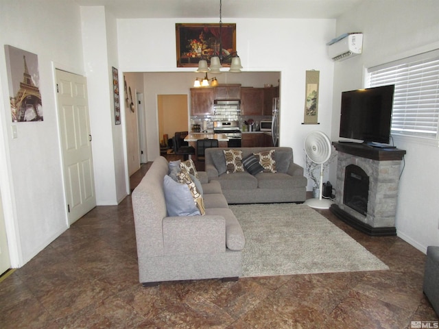 living room featuring a notable chandelier, an AC wall unit, and a fireplace