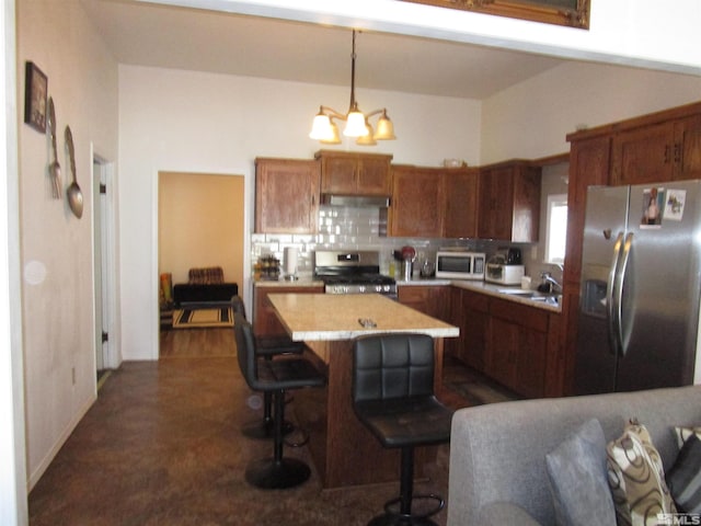 kitchen with pendant lighting, a center island, a notable chandelier, stainless steel appliances, and extractor fan