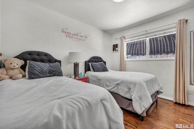 bedroom with dark hardwood / wood-style floors