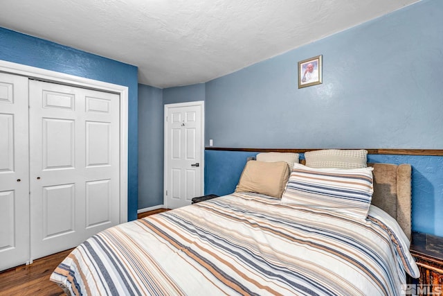 bedroom featuring hardwood / wood-style flooring, a textured ceiling, and a closet