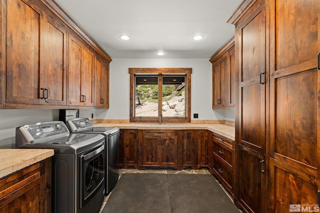 laundry area with tile patterned floors, washing machine and dryer, sink, and cabinets