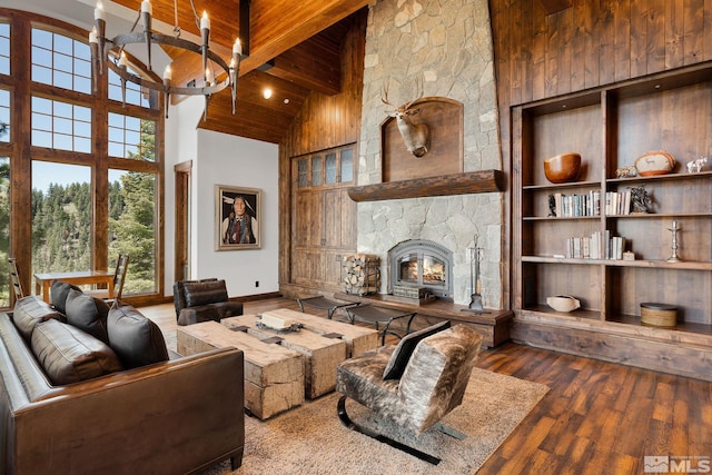 living room with a stone fireplace, hardwood / wood-style floors, and high vaulted ceiling