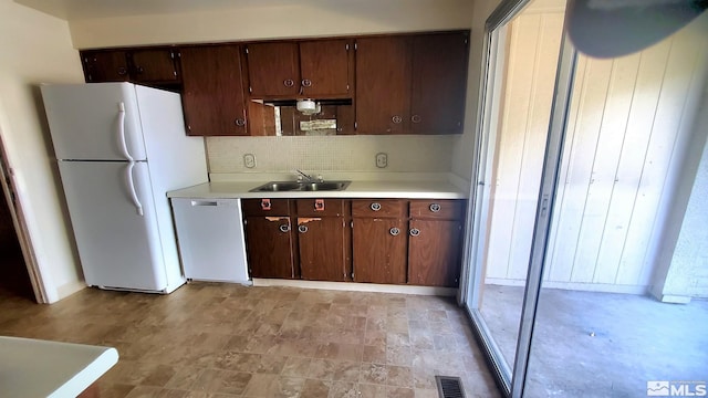 kitchen with sink, dark brown cabinets, decorative backsplash, and white appliances