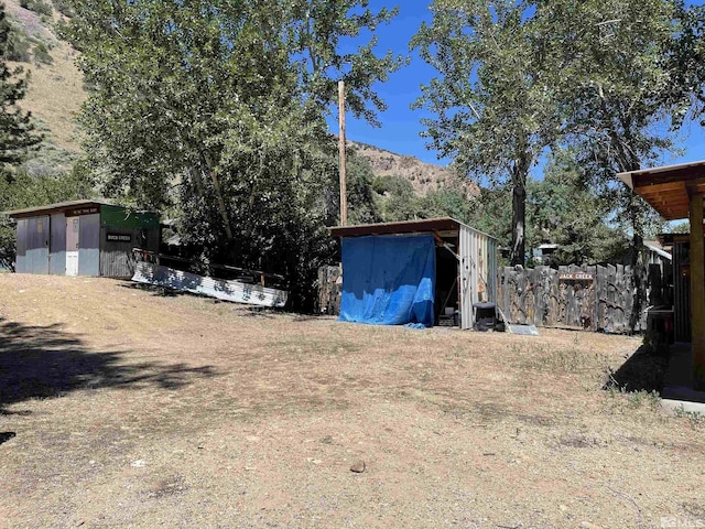 view of yard featuring a mountain view and a storage shed