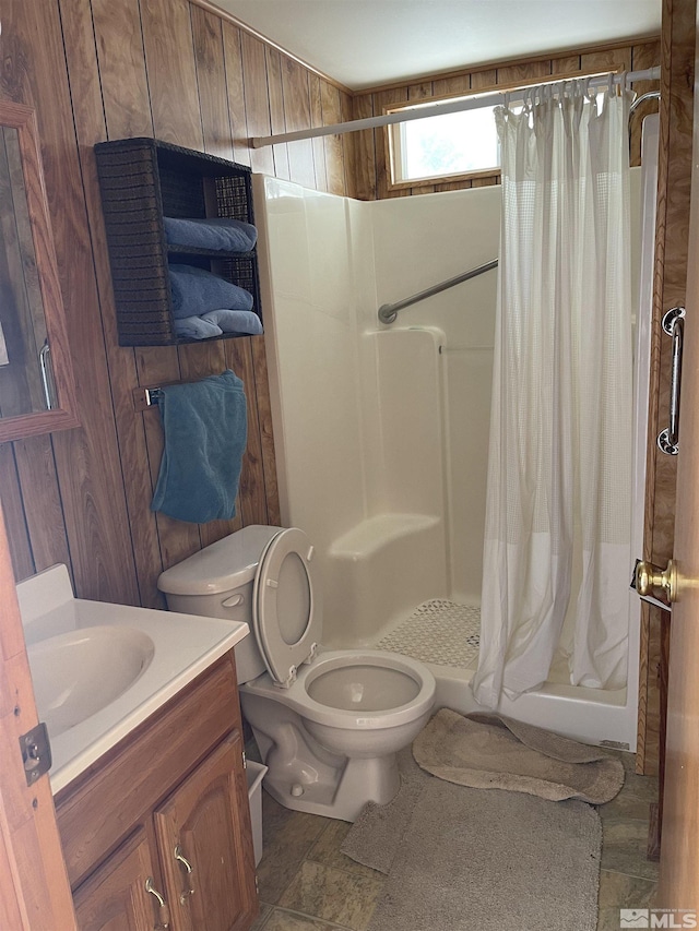 bathroom featuring vanity, toilet, curtained shower, and wooden walls