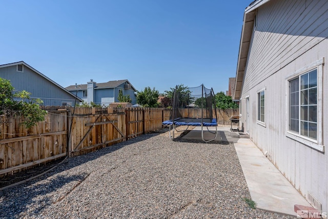 view of yard featuring a trampoline and a patio area