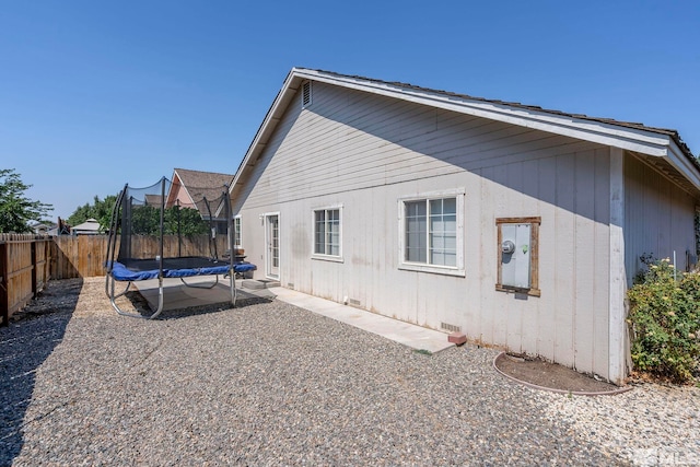 rear view of property with a trampoline