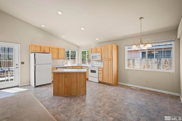 kitchen with white appliances, lofted ceiling, a kitchen island, decorative light fixtures, and a chandelier