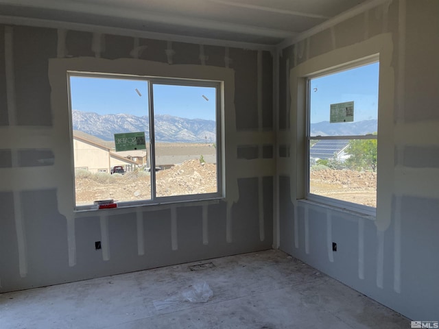 spare room featuring a mountain view and a healthy amount of sunlight