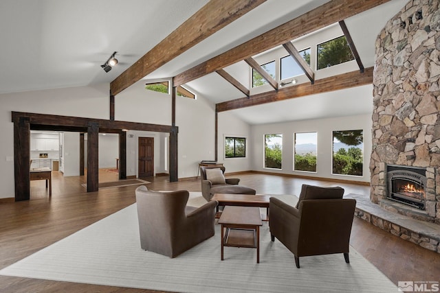 living room featuring a fireplace, wood-type flooring, high vaulted ceiling, and beam ceiling