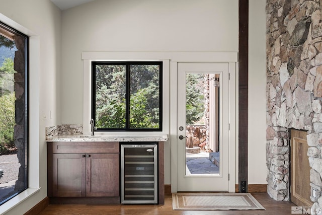 doorway to outside featuring beverage cooler, dark hardwood / wood-style floors, and indoor wet bar
