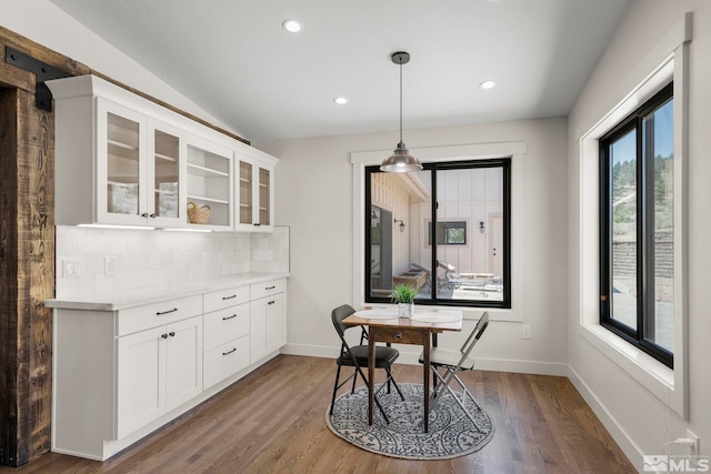 dining room with lofted ceiling and dark wood-type flooring