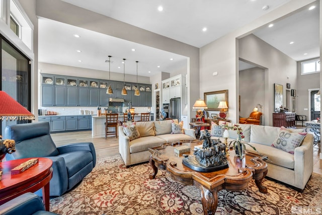 living room featuring light hardwood / wood-style floors and a towering ceiling