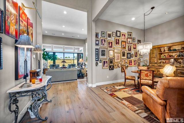 sitting room featuring a chandelier, hardwood / wood-style floors, and a high ceiling