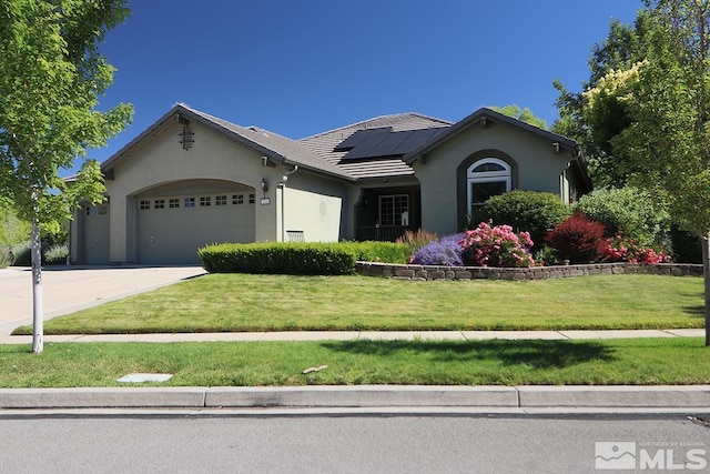 view of front of property with solar panels, a garage, and a front lawn