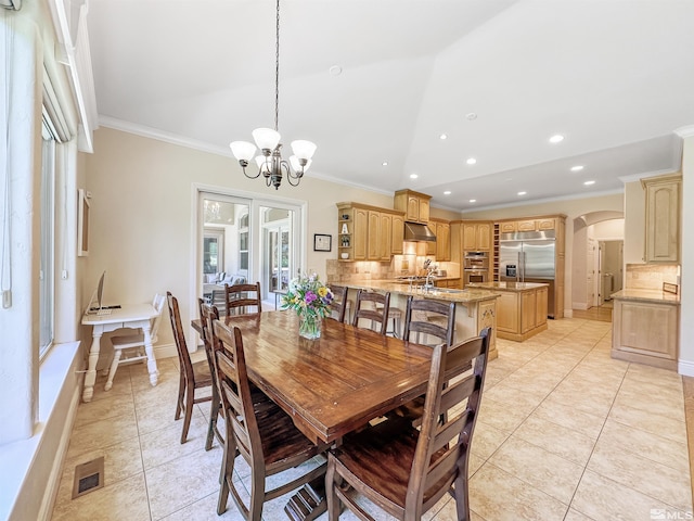 tiled dining room with crown molding, a notable chandelier, and vaulted ceiling