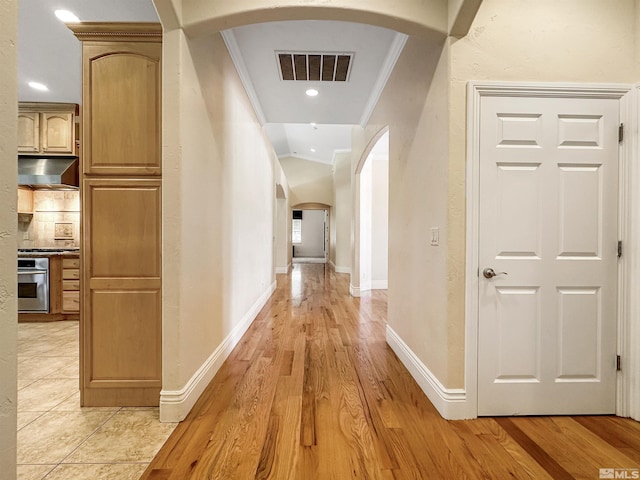 corridor with crown molding and light hardwood / wood-style floors