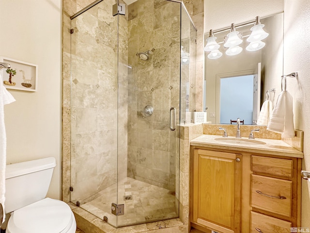 bathroom featuring toilet, an enclosed shower, and vanity