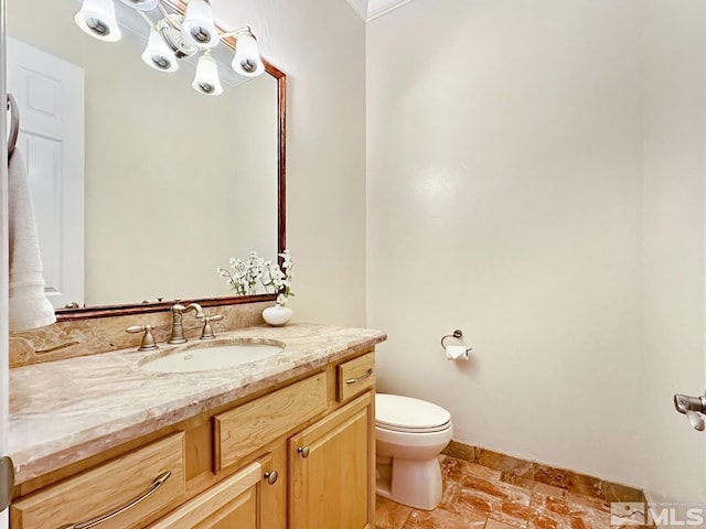 bathroom with vanity, toilet, and ornamental molding