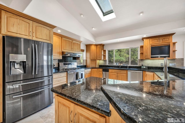 kitchen featuring sink, stainless steel appliances, tasteful backsplash, lofted ceiling with skylight, and dark stone counters