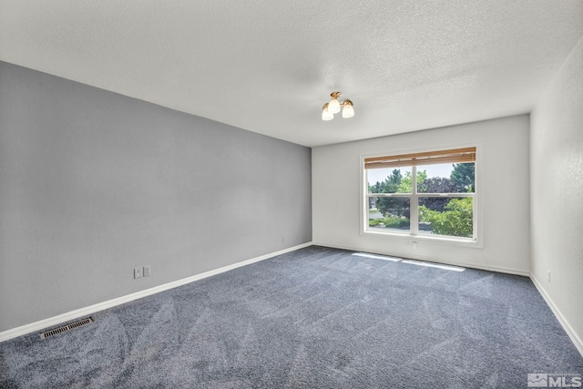 spare room with a textured ceiling and carpet floors