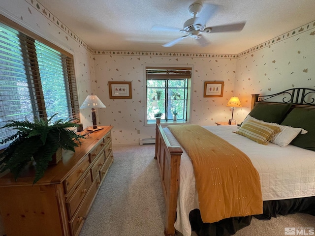 bedroom with light colored carpet, a textured ceiling, ceiling fan, and baseboard heating