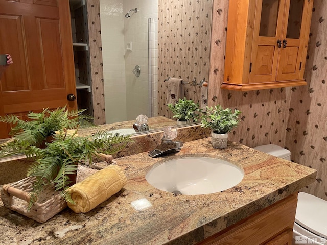 bathroom featuring vanity, a shower with shower door, and toilet