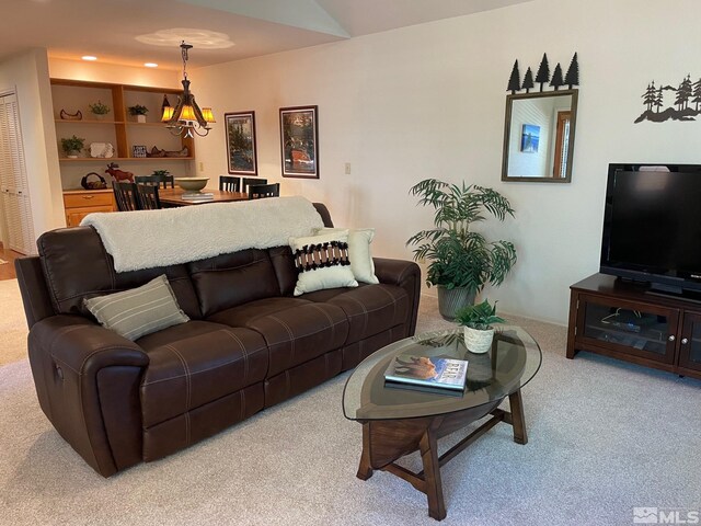 living room with a notable chandelier, carpet floors, and built in features