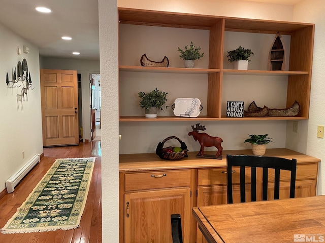 kitchen with butcher block counters, light hardwood / wood-style flooring, and baseboard heating