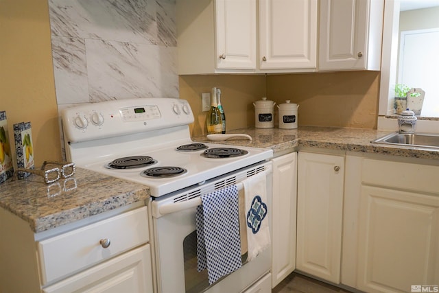 kitchen featuring light stone countertops, white cabinetry, white range with electric stovetop, and sink