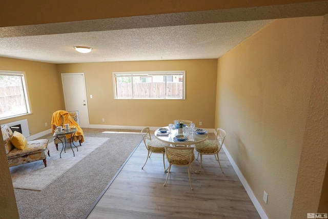 dining area featuring hardwood / wood-style floors and a textured ceiling