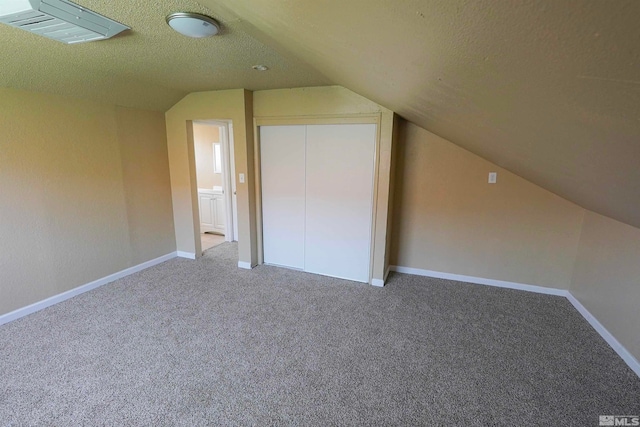 additional living space with carpet floors, a textured ceiling, and vaulted ceiling