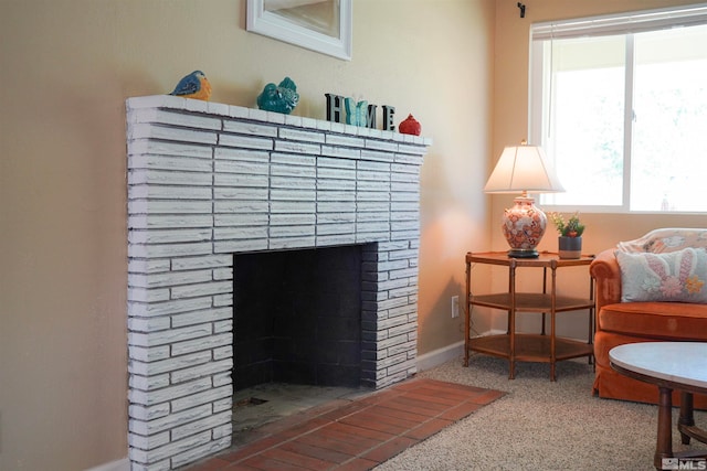 living area featuring carpet flooring and a brick fireplace