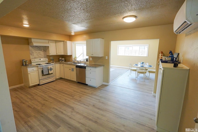 kitchen featuring a wall mounted air conditioner, white range with electric stovetop, dishwasher, and white cabinetry