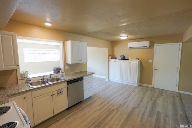 kitchen featuring an AC wall unit, dishwasher, white cabinets, and sink