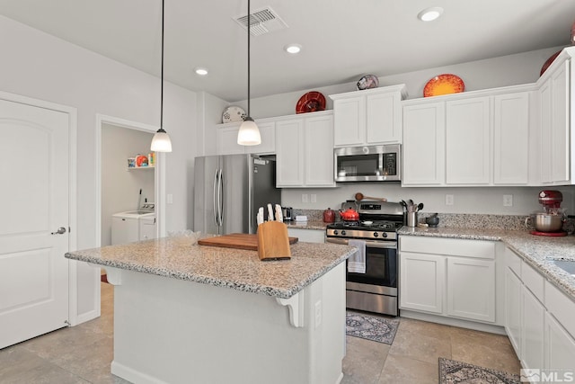 kitchen featuring separate washer and dryer, white cabinets, and stainless steel appliances