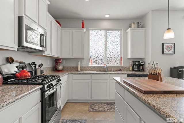 kitchen featuring light stone countertops, white cabinets, appliances with stainless steel finishes, and sink