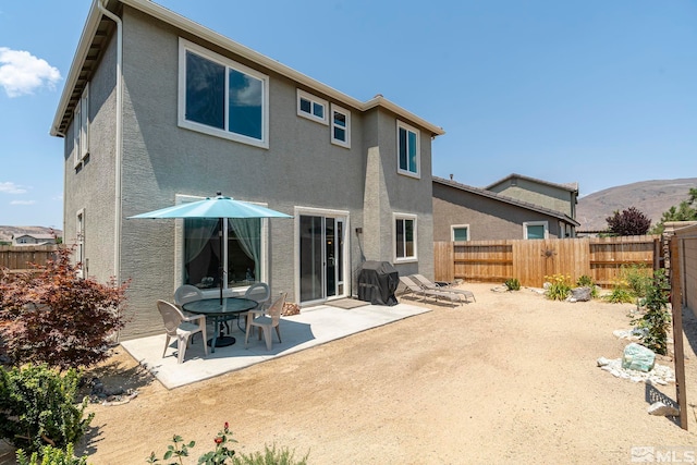 rear view of property featuring a patio area and a mountain view