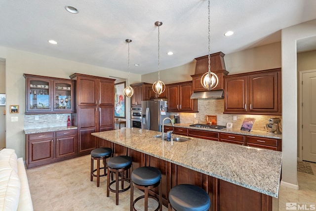 kitchen featuring appliances with stainless steel finishes, sink, a large island, and light tile patterned floors