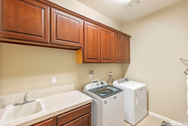 washroom featuring sink, cabinets, washer and clothes dryer, and light tile patterned flooring