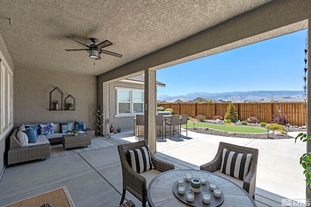 view of patio / terrace featuring a mountain view, ceiling fan, and outdoor lounge area