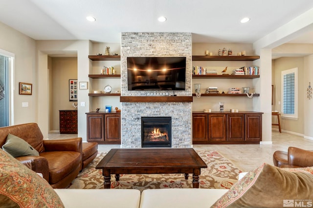 living room featuring built in shelves, light tile patterned flooring, and a fireplace