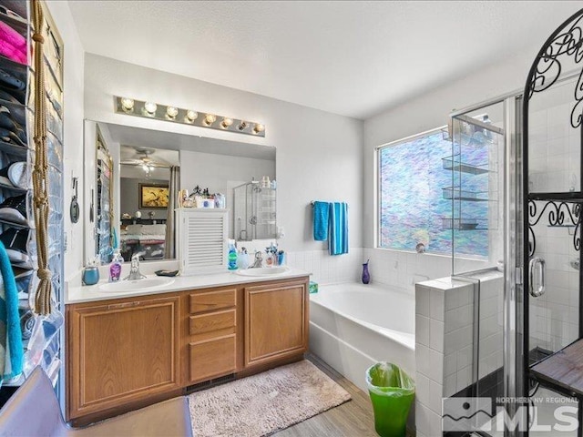 full bath featuring double vanity, a stall shower, a sink, and a bath