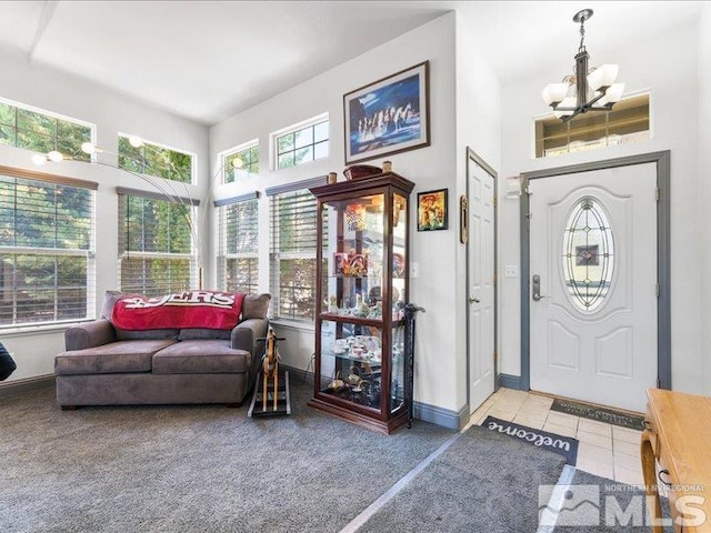 carpeted entryway featuring a notable chandelier