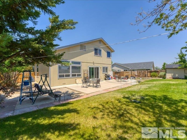 rear view of property with a yard, a patio, and fence