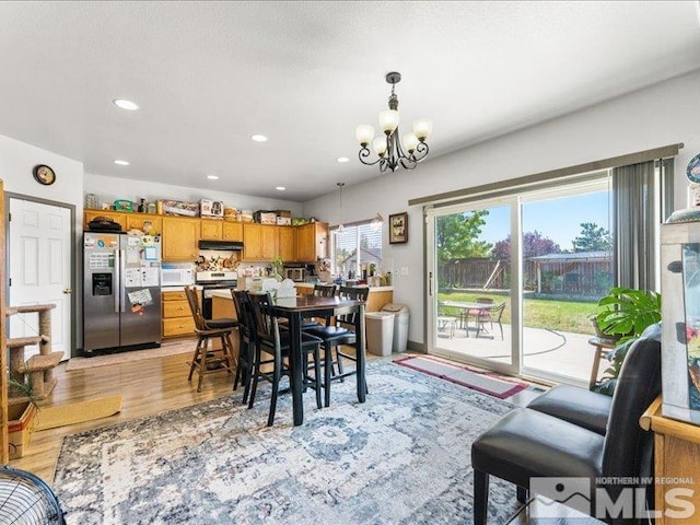 dining room featuring light wood finished floors, recessed lighting, and a notable chandelier