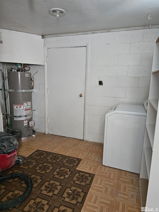 clothes washing area with washer / dryer and strapped water heater